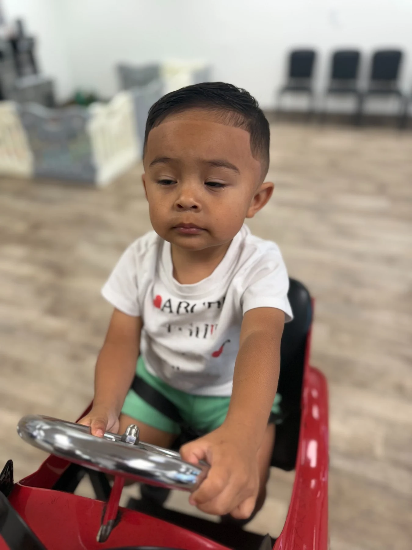 Young child enjoying a themed salon car chair